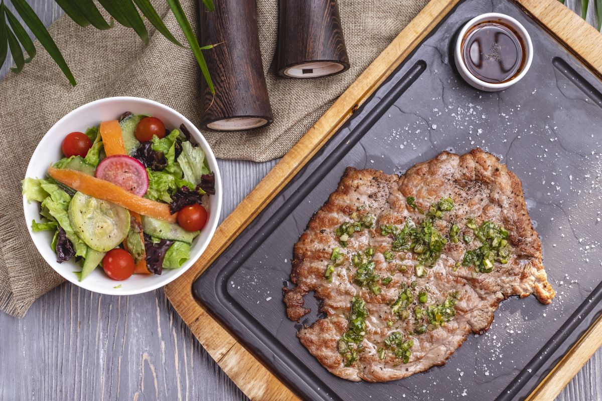 Expertly slicing cooked bottom round steak against the grain to enhance tenderness.